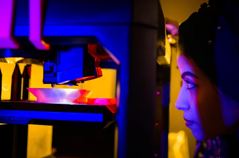 Student watching 3D printer at work