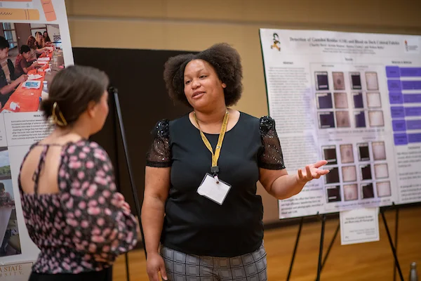 Student discussing poster presentation at Emporia State University's Research & Creativity Day