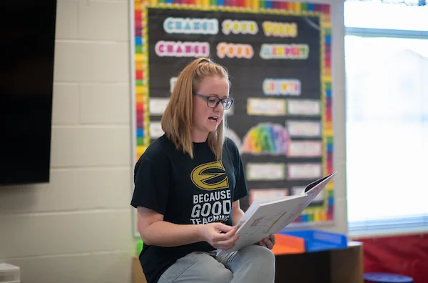 Elementary teacher reading books to students