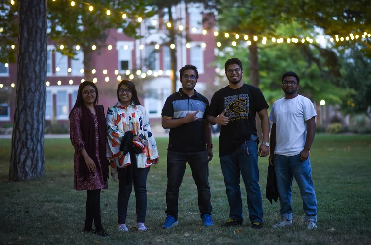 Emporia State University students posting for photo in front of Plumb Hall