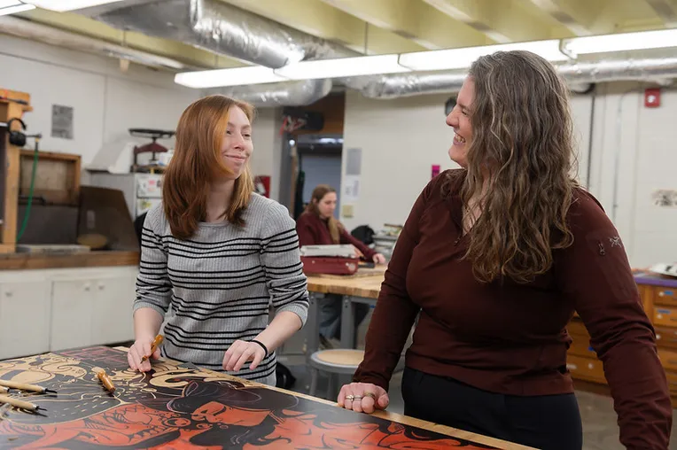 Student working with teacher on printmaking project