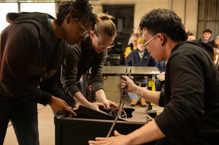 Guest working with students on glass demos