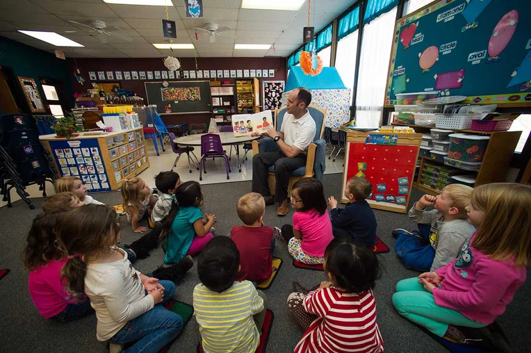 Students listening to man reading to them