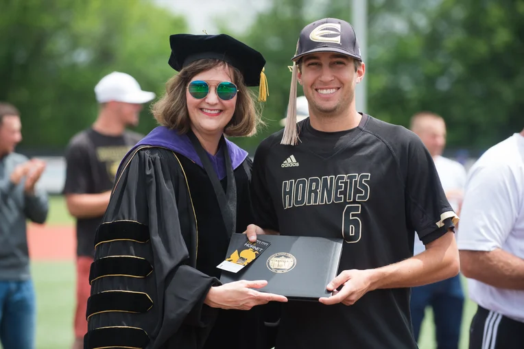 President Allison Garrett posing with baseball player