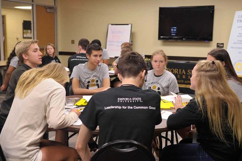 Students sitting around a table discussing ideas.