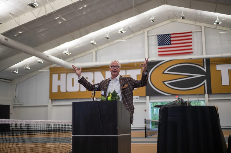 Ken Hush, Emporia State interim president, speaks at podium during Kossover Tennis Complex ribbon cutting