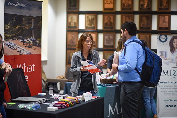 A female recruiter for Conoco Phillips talks with a male student about career possibilities.