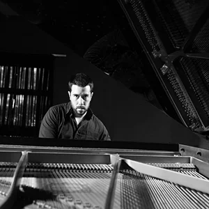 Man poses at piano