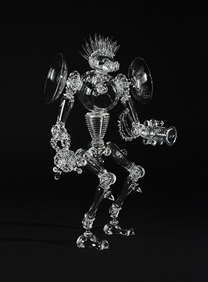 A clear glass sculpture that looks like a robot with a spiked mohawk