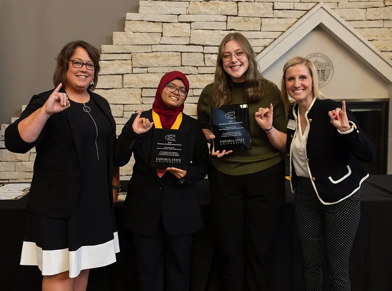 A group of 4 women face the camera.