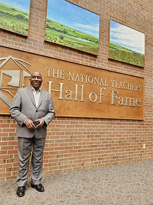 Man stands in front of sign that says National Teachers Hall of Fame